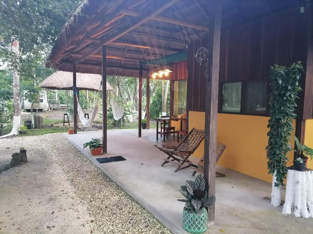 Terraza en tonos ocres de una cabaña con techo de palapa